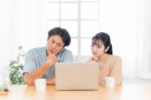 PCの前で考える夫婦