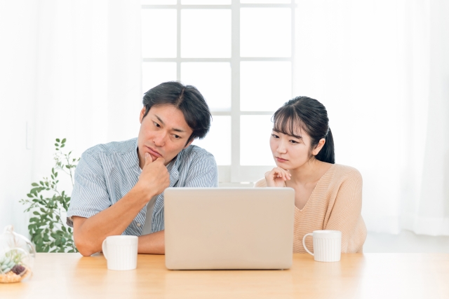 PCの前で考える夫婦